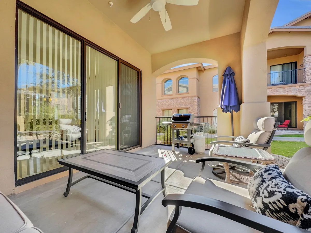 This image presents a well-appointed patio area with stylish furniture, a grill, and an umbrella, designed for outdoor dining or morning coffee. The setup invites guests to savor meals outside or host a barbecue with friends, blending comfort with the joys of outdoor living.